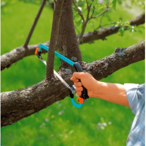 Gardena combisystem Bügelsäge beim Sägen eines Astes im Garten.
