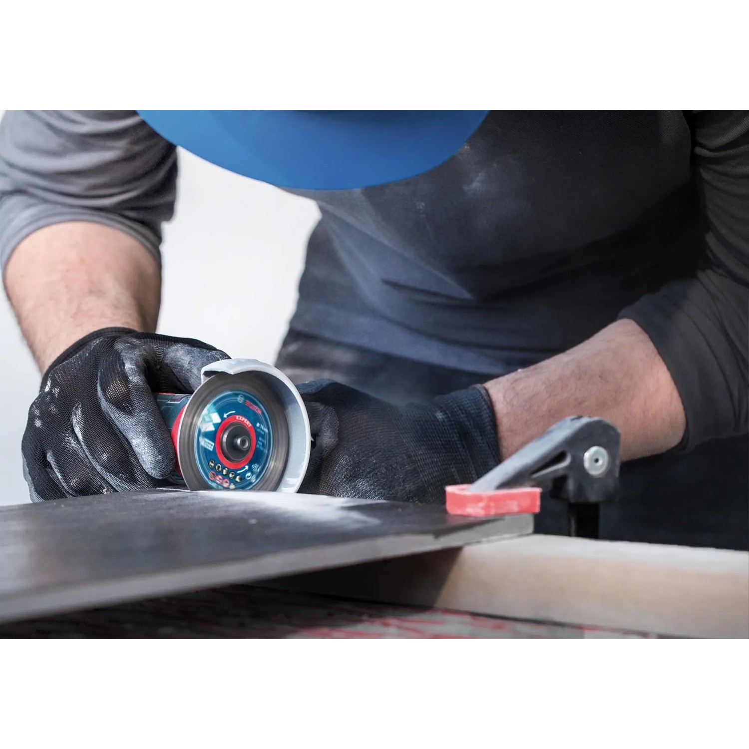 Bosch Expert Diamanttrennscheibe schneidet Fliese mit Winkelschleifer. Zubehör für präzise Schnitte.