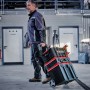 Ein Mann zieht einen Einhell E-Case Werkzeugkoffer Trolley mit Werkzeug in einer Werkstatt.