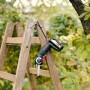 Bosch Akku-Säge AdvancedCut 18 mit Akku auf einer Holzleiter im Garten.