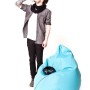Blauer Sitting Point Sitzsack Brava (120 l) mit Kopfhörern, daneben eine Person.