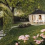 Palmako Holz-Pavillon Hanna, grau grundiert, im Garten mit Rosen und Gartenweg.