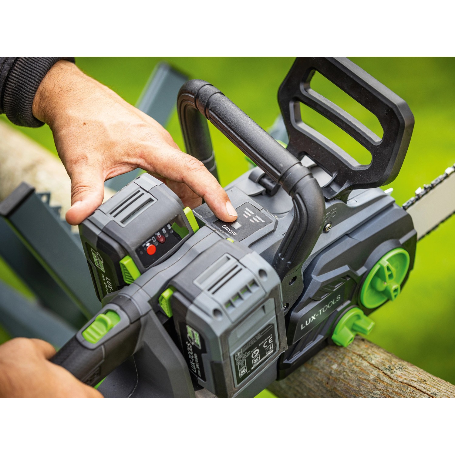 LUX-TOOLS Akku-Kettensäge A-KS-2x20/405 1 PowerSystem in Nutzung, Bedienelement wird betätigt.