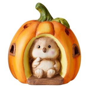 Orangefarbener Terrakotta-Kürbis mit niedlicher Igel-Figur und LED-Beleuchtung. Perfekt für herbstliche Dekoration.