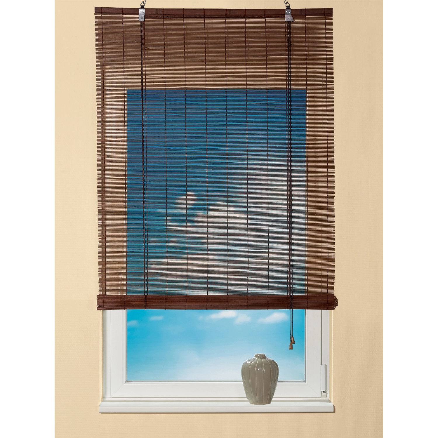 OBI Bambus-Raffrollo Teak, 100x160 cm, am Fenster mit Blick auf blauen Himmel.