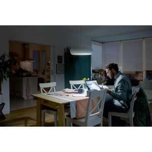 Mann arbeitet unter Philips LED E14 Lampe mit Neutralweiß in Wohnzimmer. Energiesparend und langlebig.