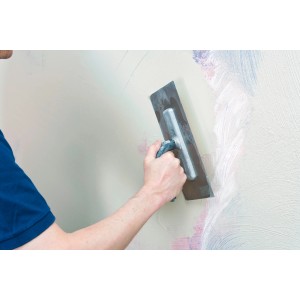 Handwerker glättet Wand mit Knauf Rotband Flächenspachtel. Ausgleichsmasse für Innen.