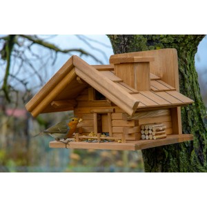 Braun gebeiztes Dobar Vogelhaus im Berghütten-Design mit Vogel am Futterplatz.