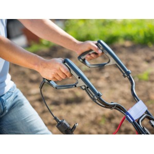 Detailaufnahme: Hände bedienen die LUX Elektro-Bodenhacke E-BH 1400-43 im Garten.