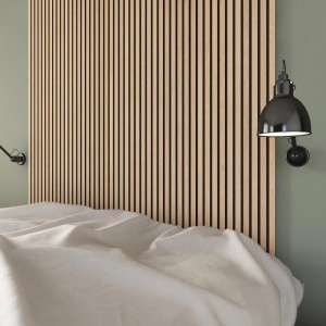 Denpanels Akustikpaneel Eiche als Betthaupt mit Lampe an grüner Wand.