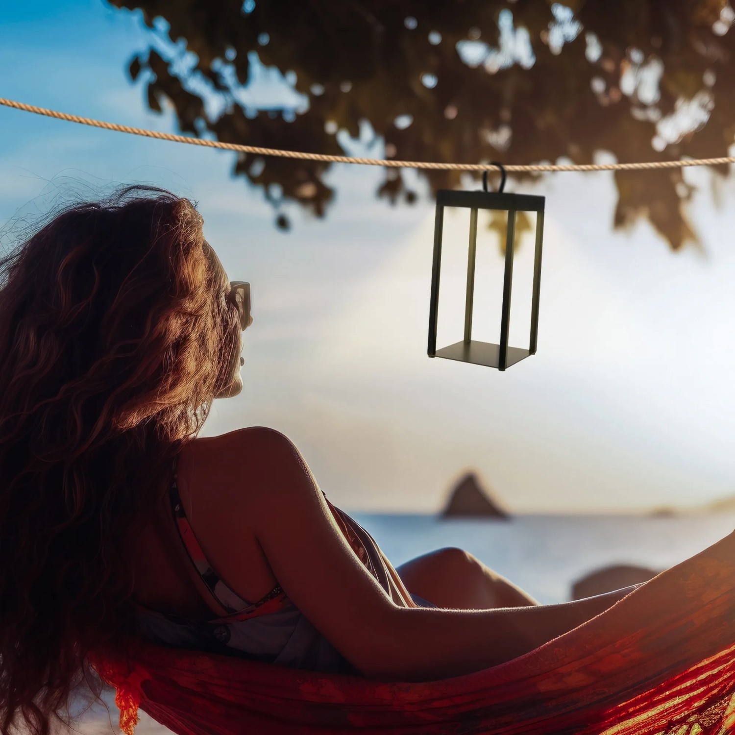 Schwarze Brilo LED Laterne Luca, dimmbar, spritzwassergeschützt, hängt über einer Frau in der Hängematte.