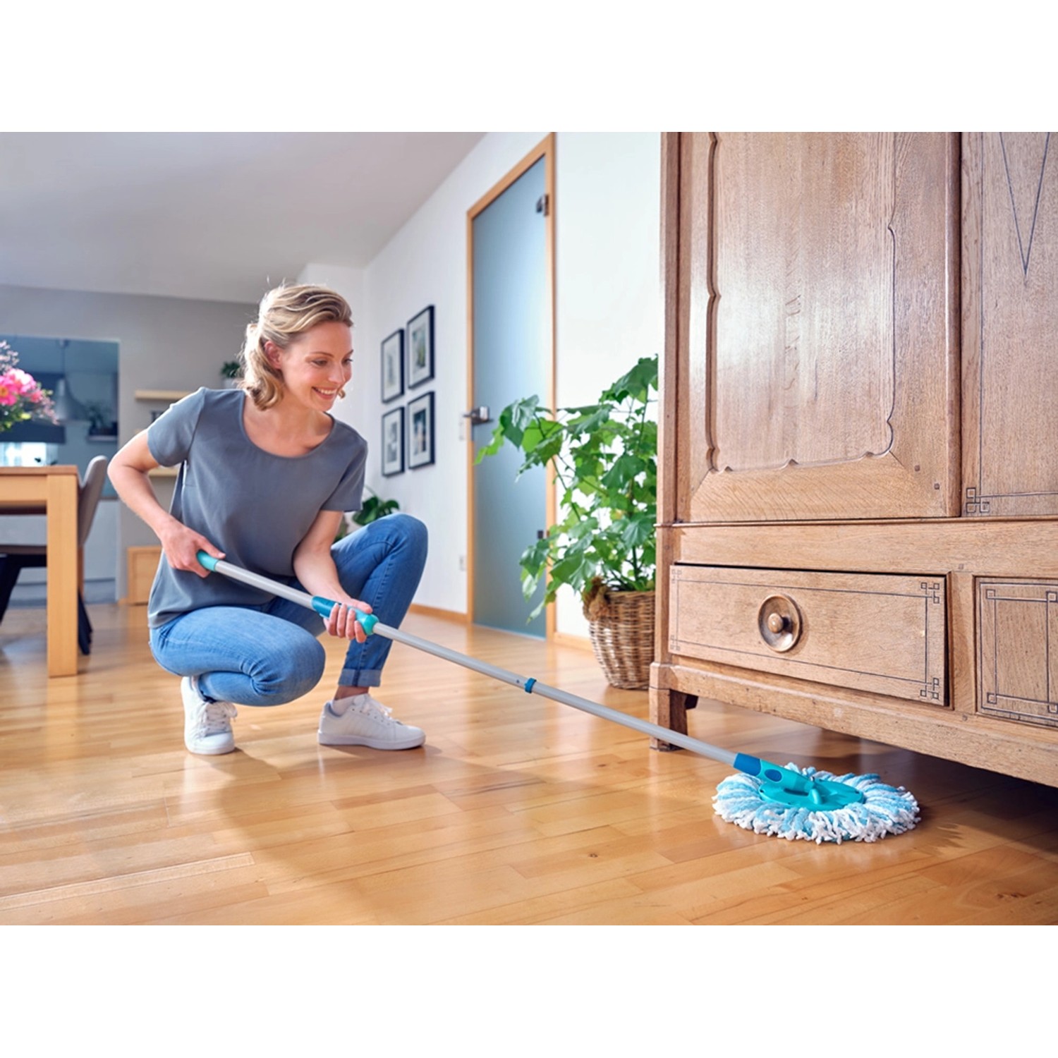 Frau wischt Boden mit Leifheit Clean Twist Disc Mop Ergo Reinigungsgerät.