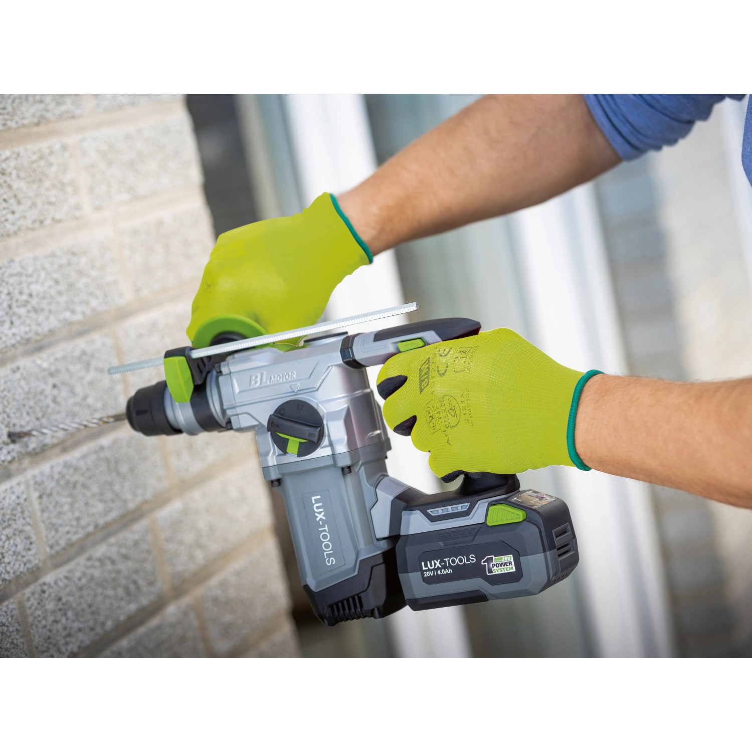 Mann bohrt mit LUX-TOOLS Akku-Bohrhammer, trägt LUX-TOOLS Arbeitshandschuhe Gr. 8.