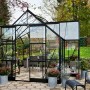 Halls Gewächshaus Garden Room, 12,9 m², schwarz, mit Glas und Aluminiumrahmen im Garten.