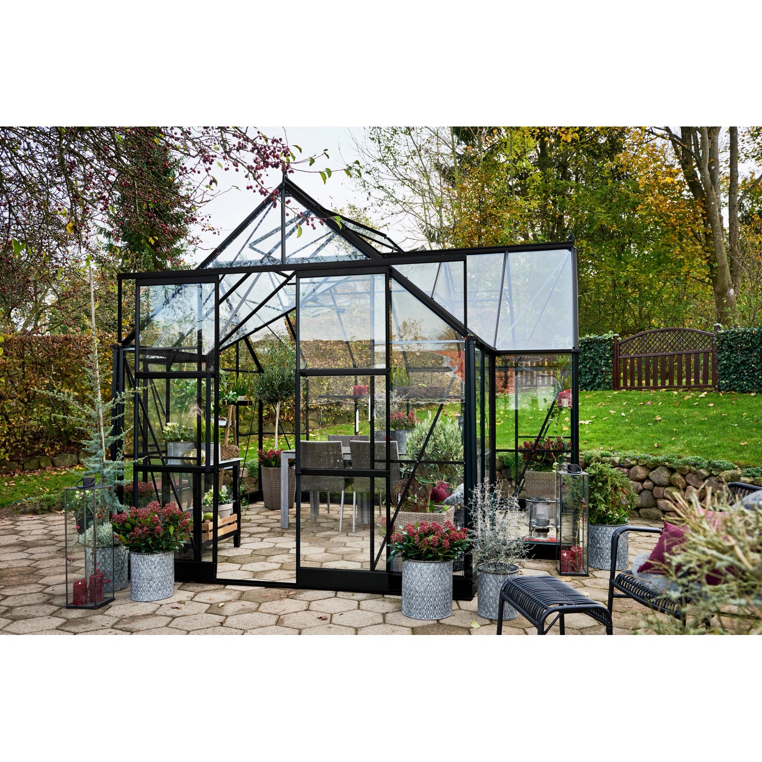 Halls Gewächshaus Garden Room, 12,9 m², schwarz, mit Glas und Aluminiumrahmen im Garten.