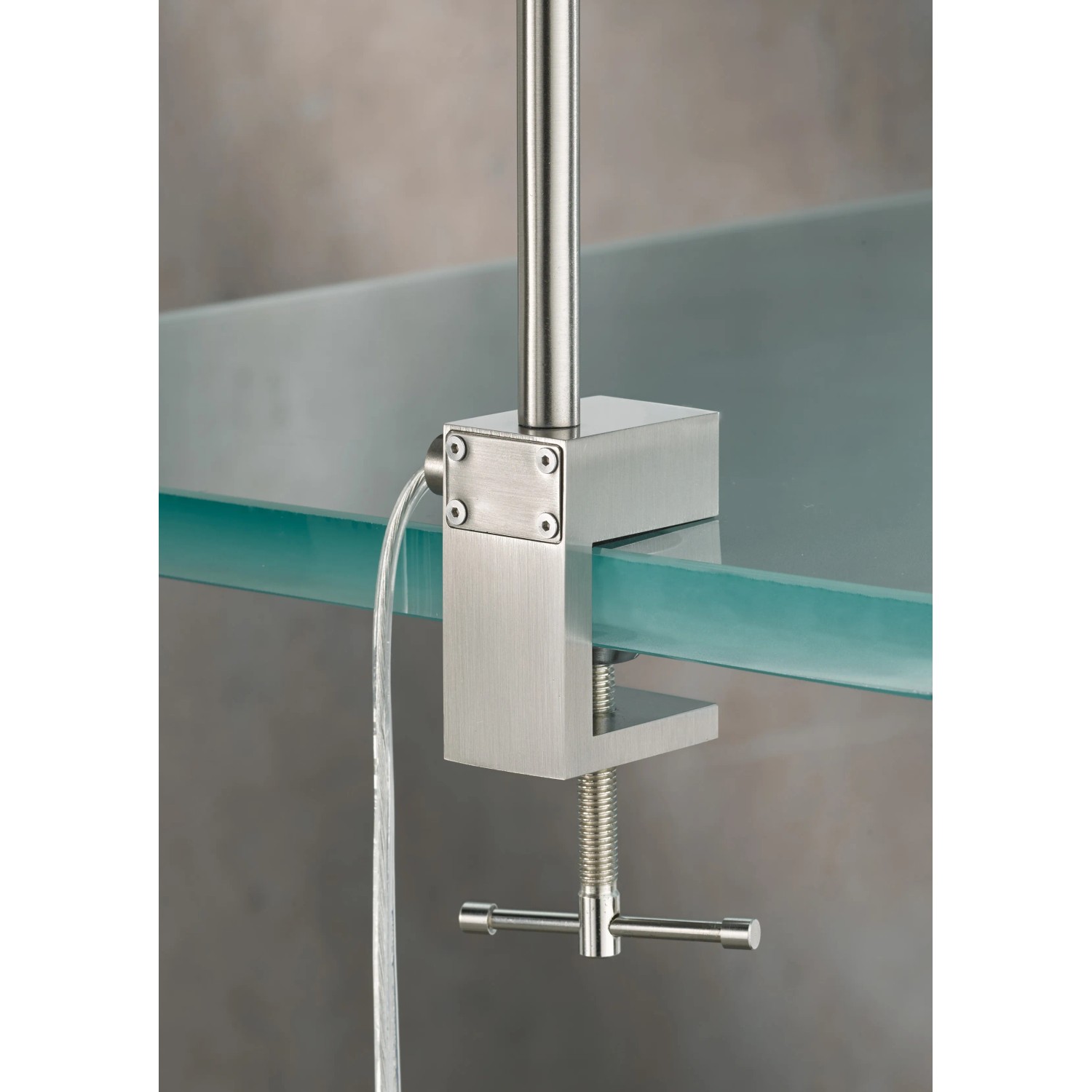 Detailaufnahme: Fischer & Honsel LED-Klemmleuchte Sten in Nickel an einer Glasplatte befestigt.