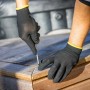 Mann schraubt mit LUX Arbeitshandschuhen Green Glove Gr. 9 eine Holzterrasse zusammen.
