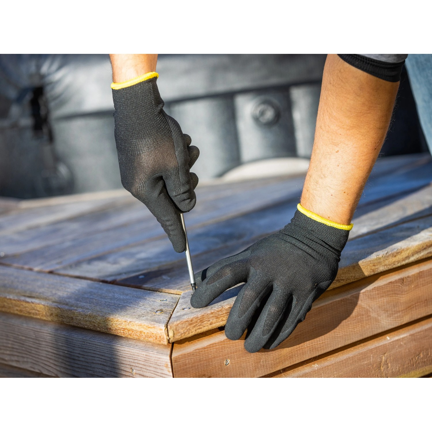 Mann schraubt mit LUX Arbeitshandschuhen Green Glove Gr. 9 eine Holzterrasse zusammen.
