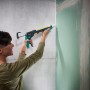 Frau benutzt wolfcraft Kartuschenpresse MG 400 Ergo für Silikonarbeiten an Wand.