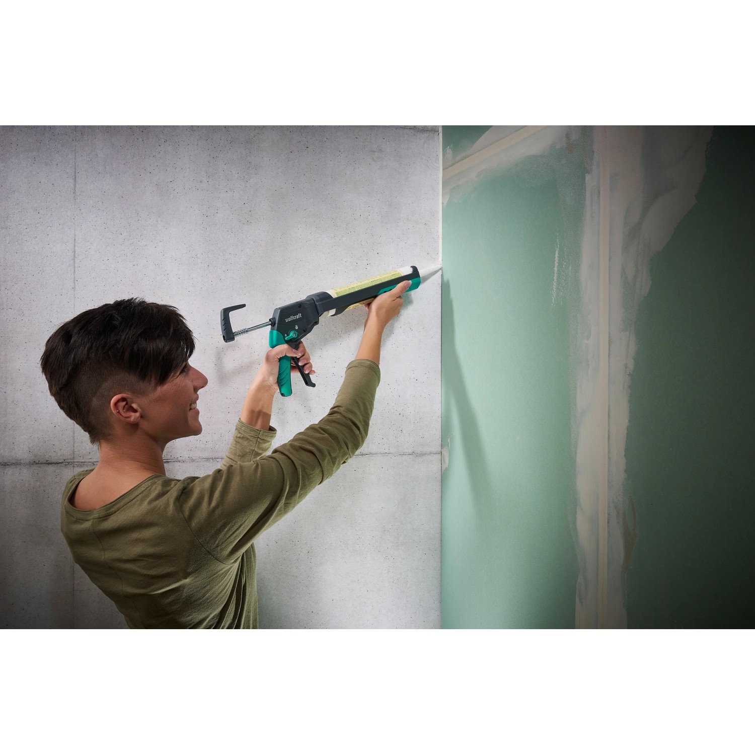 Frau benutzt wolfcraft Kartuschenpresse MG 400 Ergo für Silikonarbeiten an Wand.