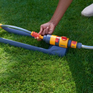 Hozelock AquaSave Pro 220 Rasensprenger in Aktion auf Rasen, gelb-grau.