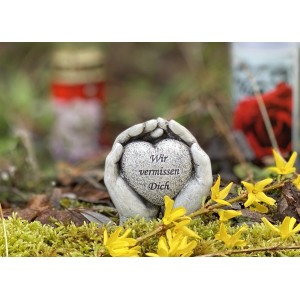 Flower Power Grabdeko: Hände mit Herz aus Kunststein, Inschrift 'Wir vermissen Dich'.