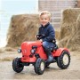 Roter BIG Trettraktor Porsche Diesel Junior mit Kind auf einem Bauernhof.