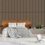Jangal Wandpaneel Solid Walnut als Akustikpaneel im Schlafzimmer hinter einem Holzbett.