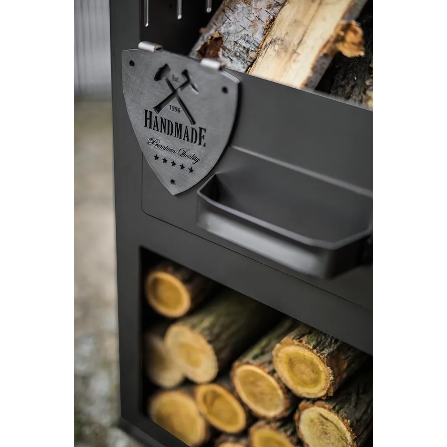 Detailansicht des CookKing Gartenofens Rosa mit Holzlagerfach und "Handmade" Logo.