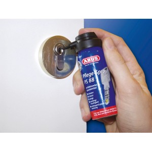 Abus Pflegespray PS88 wird in ein Türschloss gesprüht. Ideal zur Pflege von Profilzylindern.