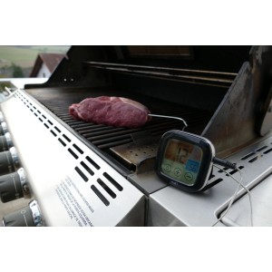 Digitales Grill-Bratenthermometer von TFA mit Temperaturfühler im Steak auf Grill.