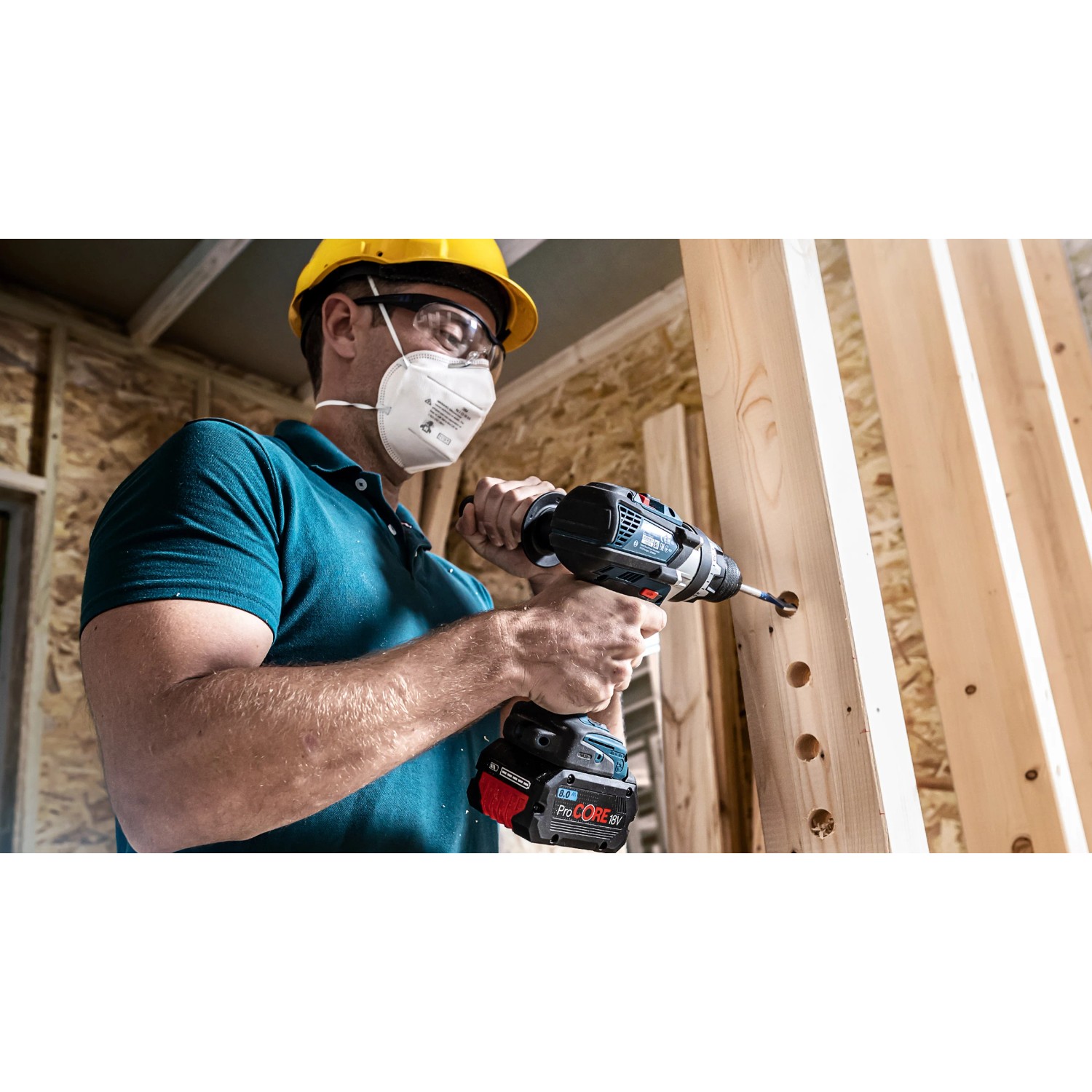 Handwerker bohrt mit Bosch Flachfräsbohrer Löcher in Holzbalken.