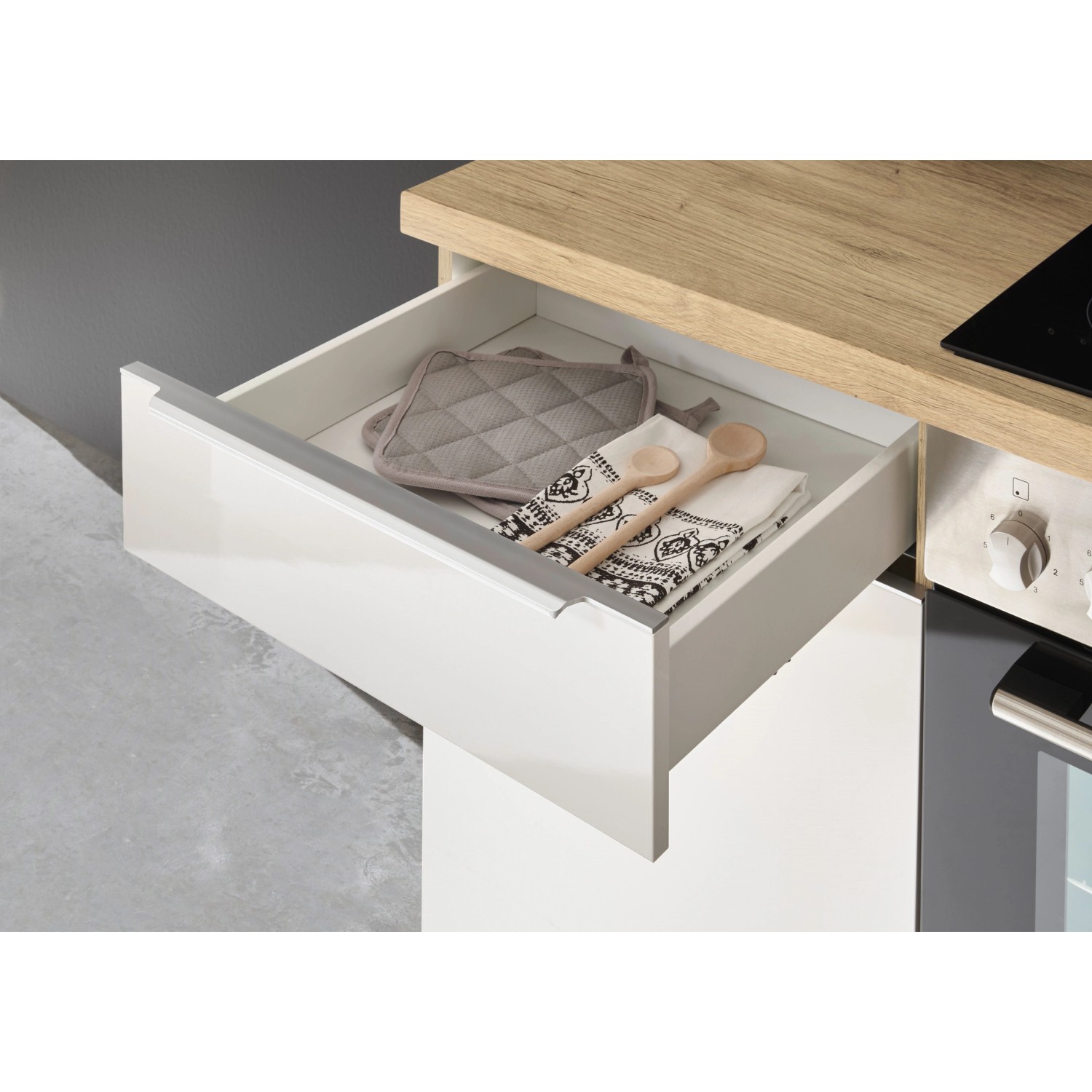 Küchenzeile Marleen: Schublade mit Kochutensilien in Artisan-Eiche/Weiß Hochglanz.