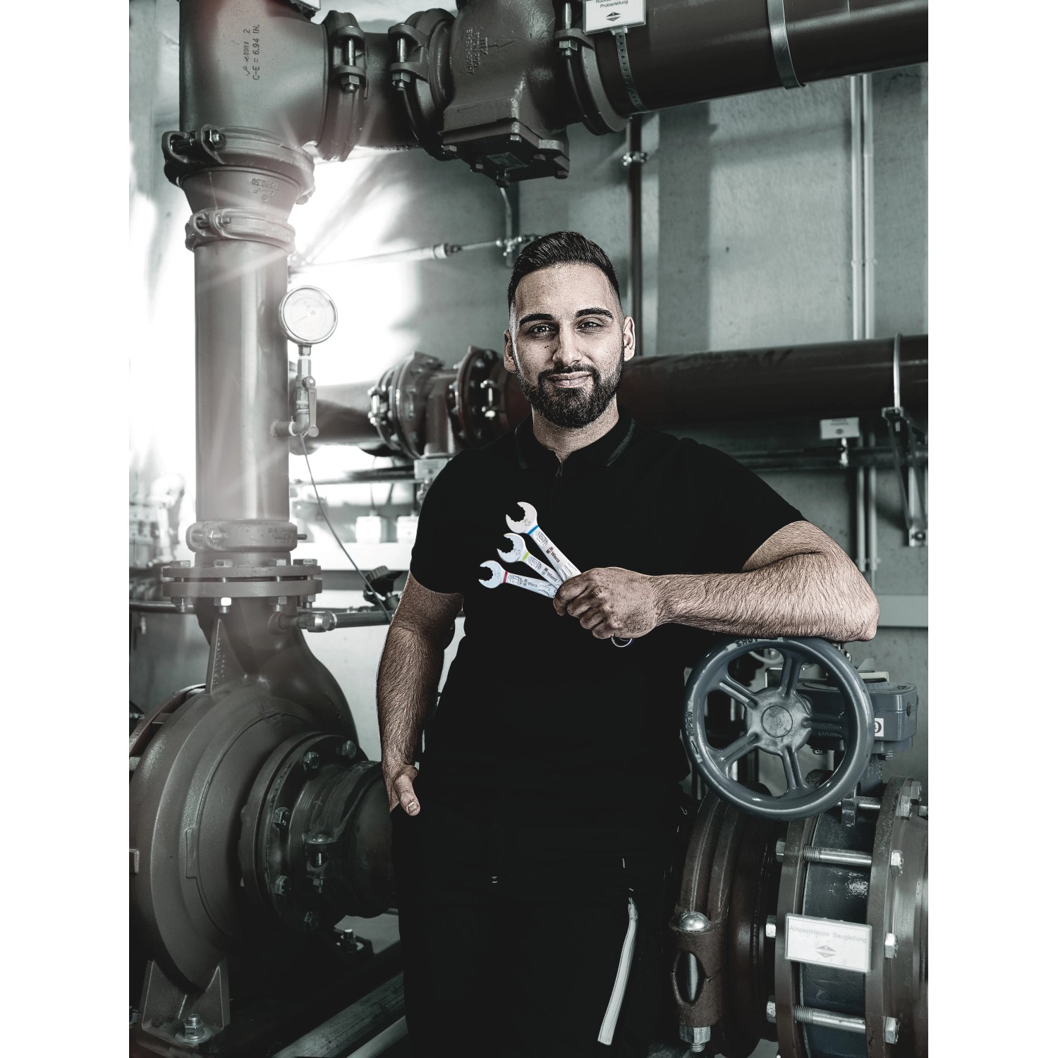 Handwerker mit Wera Ringmaulschlüssel Joker 19 mm vor Industrieanlage.