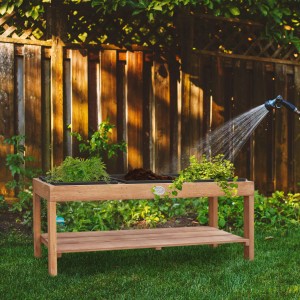 Axi Sand- und Wassertisch mit 3 schwarzen Behältern aus Holz im Garten beim Bewässern.