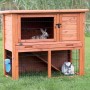 Trixie Kleintierstall Natura mit Freilaufgehege, braun, mit Kaninchen im Garten.