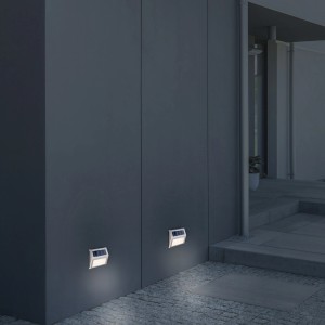 4er Set Näve LED Solar-Wandleuchten mit warmweißem Licht an einer grauen Hauswand.