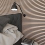 Akustikpaneel Buche/Schwarz an Schlafzimmerwand mit Lampe und Bett. Schallschutz für Wand und Decke.