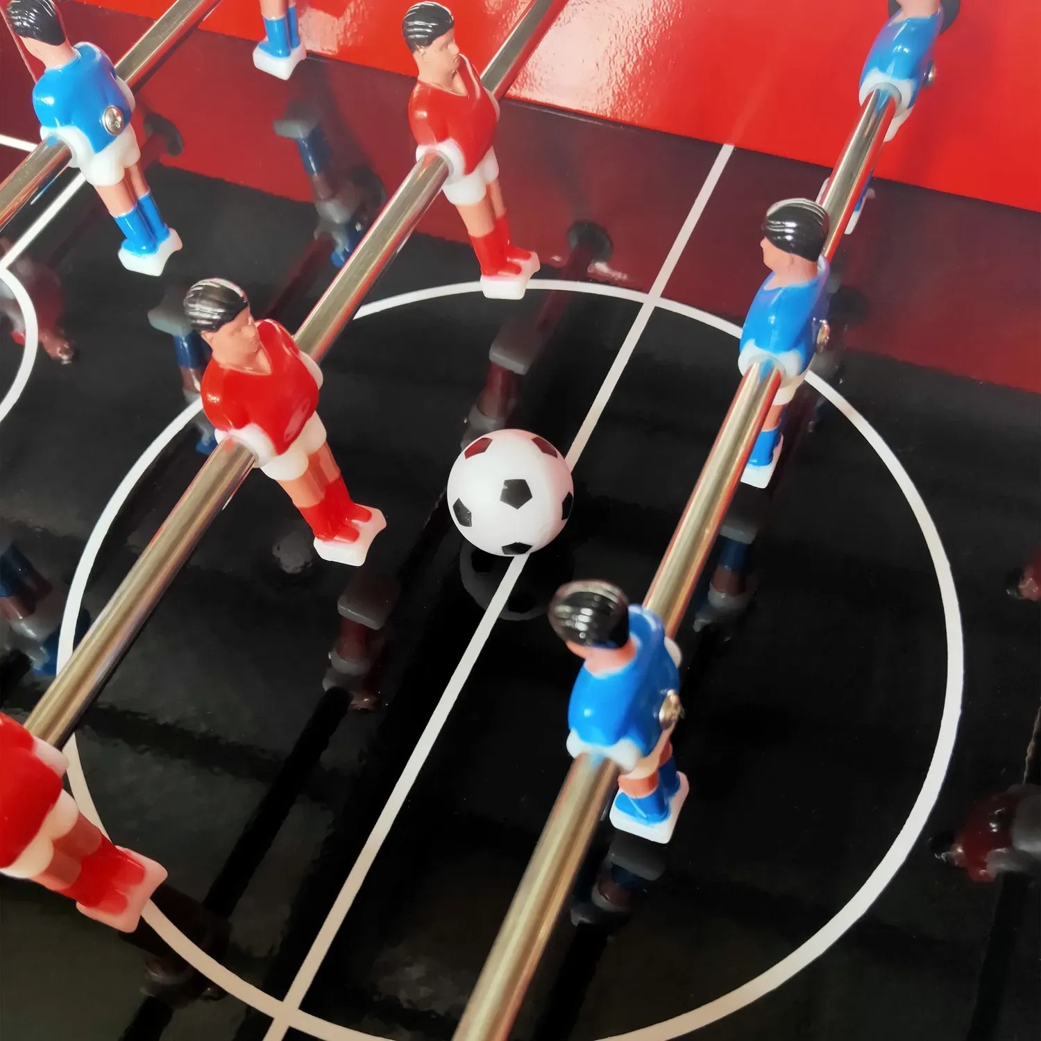 Detailaufnahme: Tischfußball-Aufsatz des roten Axi Kühlwagens mit Spielfiguren und Ball.