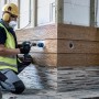 Handwerker bohrt Loch mit Bosch Expert Lochsäge Tough Material Ø 68 mm in Holzverkleidung.