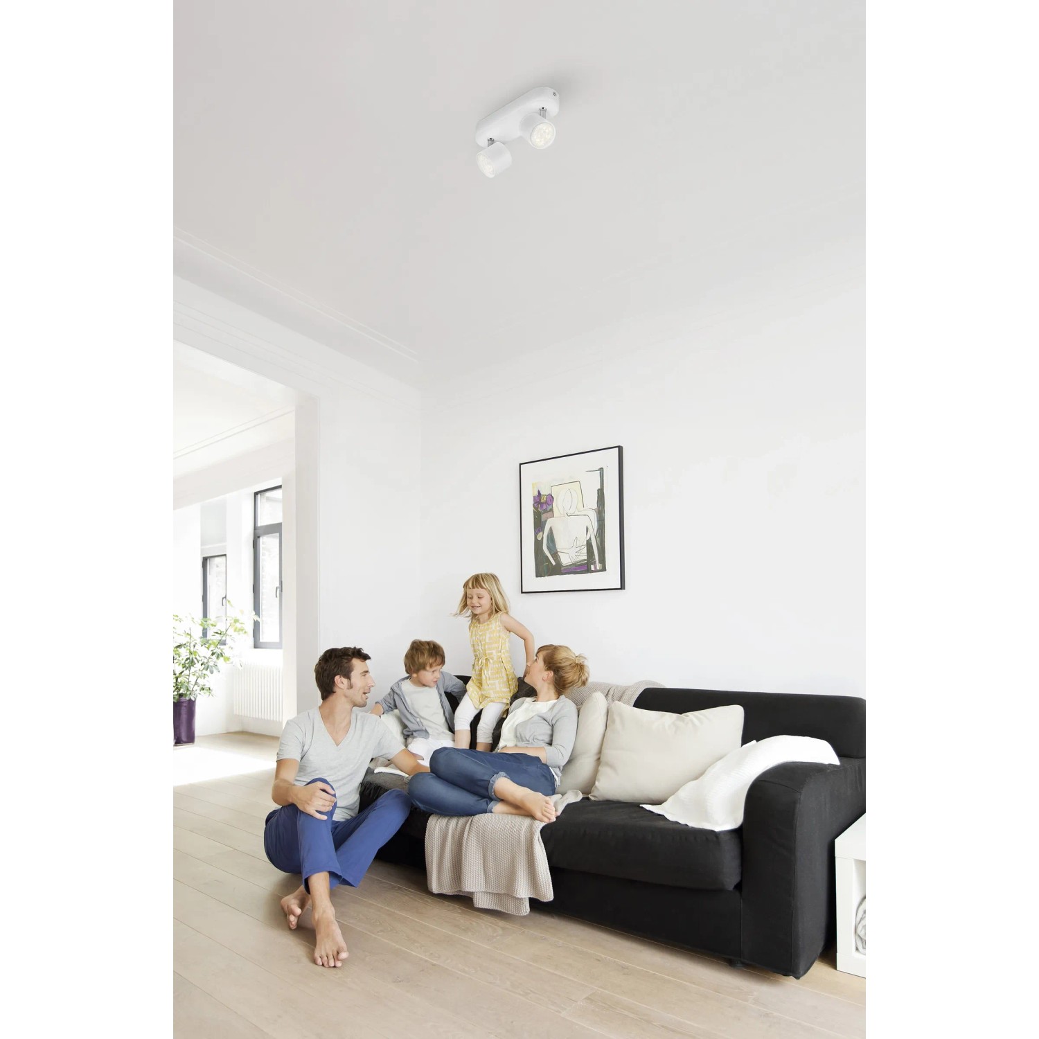 Weißer Philips LED-Doppelspot Star im Wohnzimmer mit Familie. Schwenkbare Deckenleuchte, 8W.