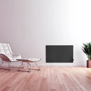 Schwarze Vasner Hybrid-Infrarotheizung Konvi 600W an Wand im Wohnraum.