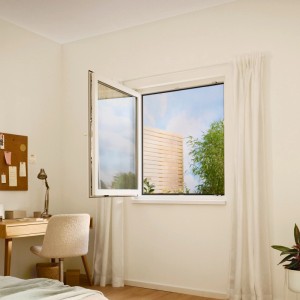 Offenes Fenster mit weißem tesa® Insect Stop Klett Fliegengitter, montiert in einem hellen Raum.
