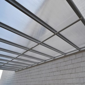 Anthrazit Terrassenüberdachung Solis Alu mit Hohlkammerplatten an Hauswand.