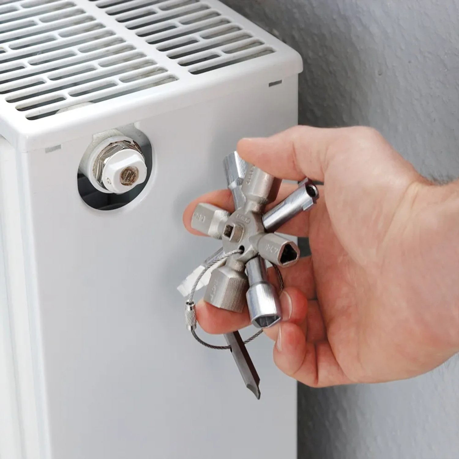 Knipex TwinKey Multifunktionsschlüssel 95mm in Nutzung an einem Heizkörper.
