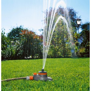 Gardena Comfort Tango Regner bewässert Rasenfläche. Teil- und Vollkreisregner mit Wasserstrahlen im Garten.