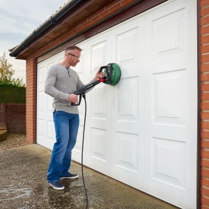 Mann reinigt Garagentor mit Bosch Multi-Flächenreiniger Aquasurf 280.