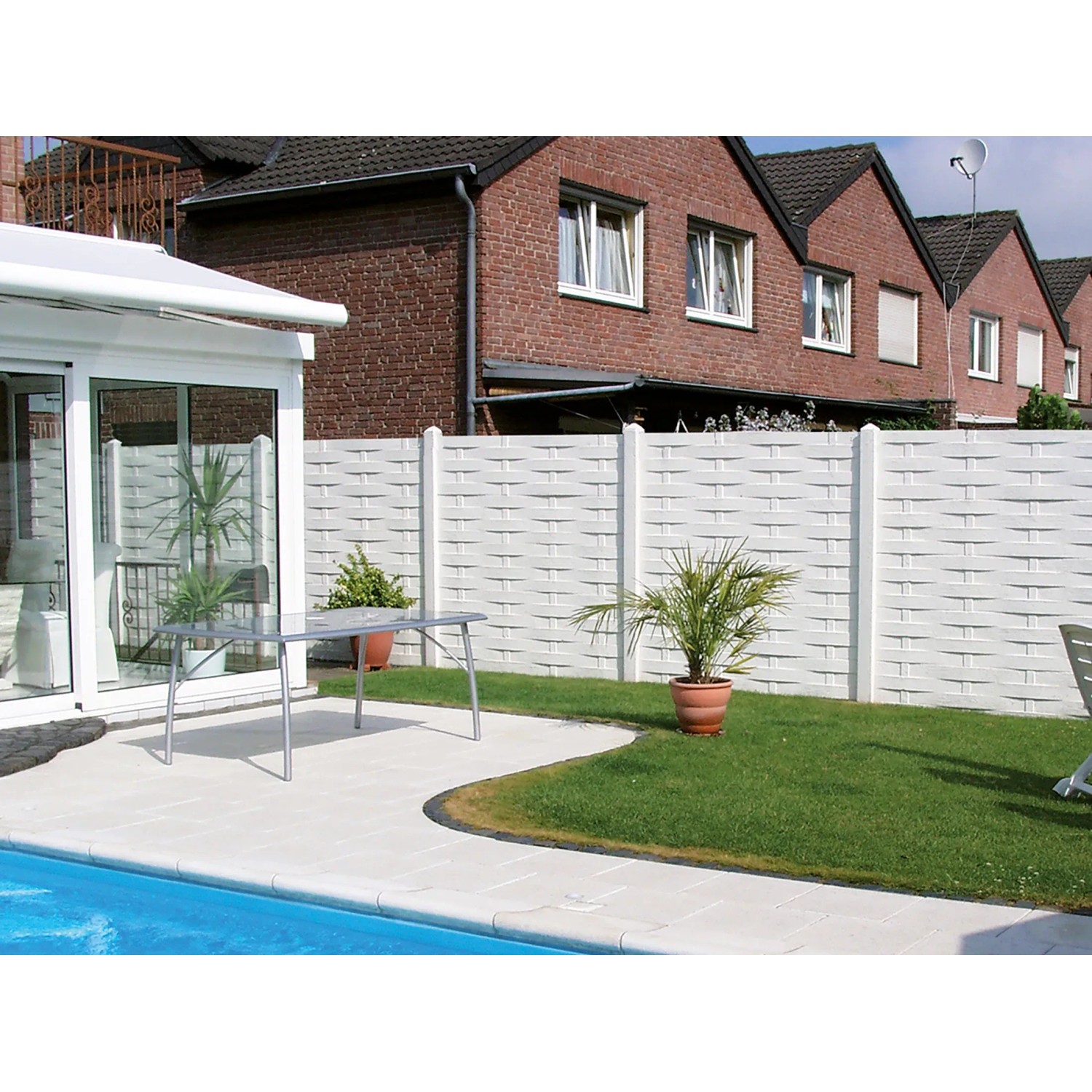 Weißer Betonzaun mit Flechtmuster als Sichtschutz im Garten. Die Zaun-Platte ist 200x38,5x3 cm groß.