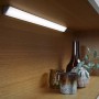 Ledvance LED-Unterbauleuchte Cabinet Corner, 35 cm, im Regal mit Deko-Elementen.