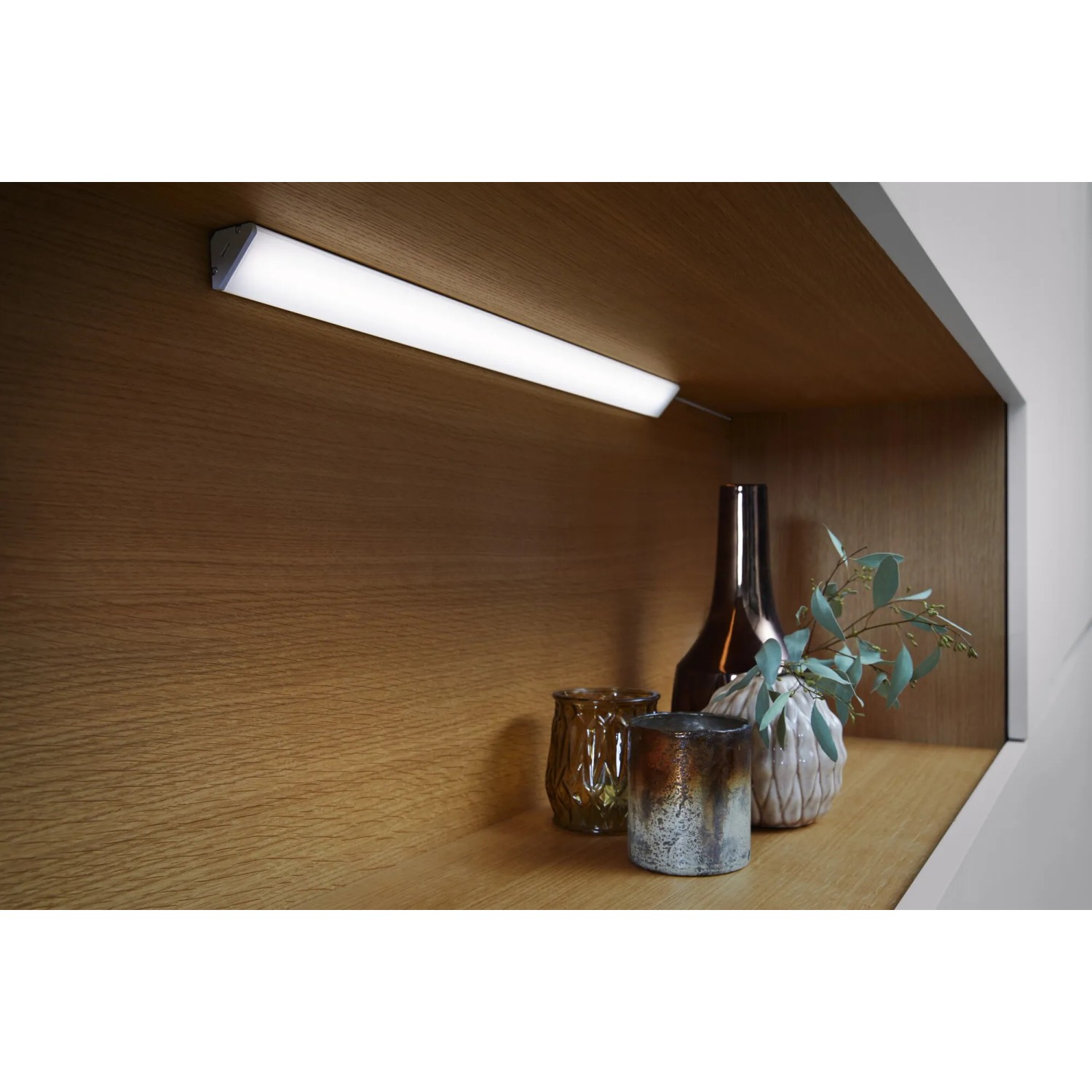 Ledvance LED-Unterbauleuchte Cabinet Corner, 35 cm, im Regal mit Deko-Elementen.